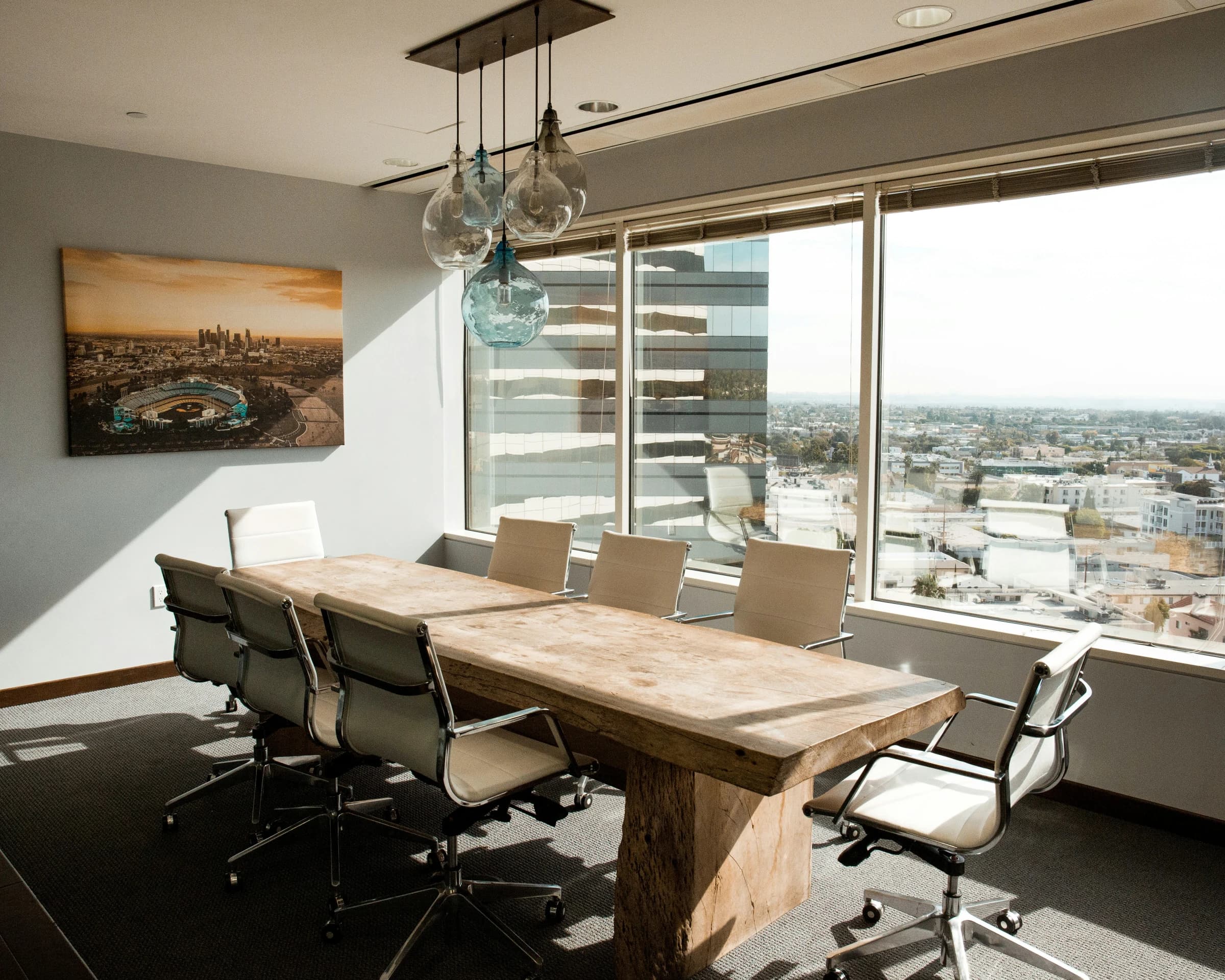 Sunlit boardroom with a timber table overlooking the city